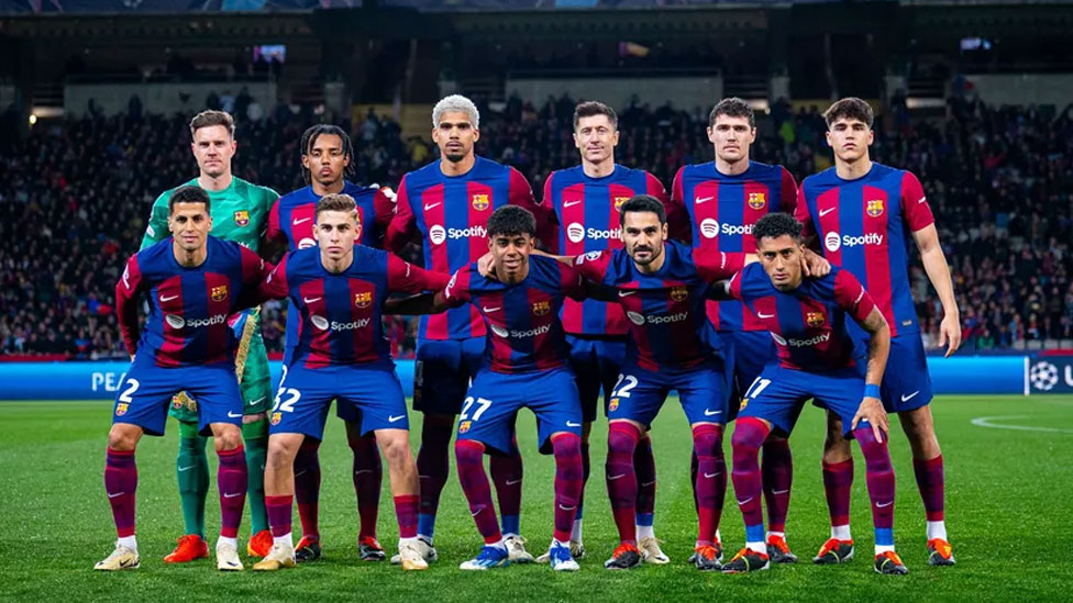 Lamine Yamal centre front row posing for a photo with the Barcelona team before the match